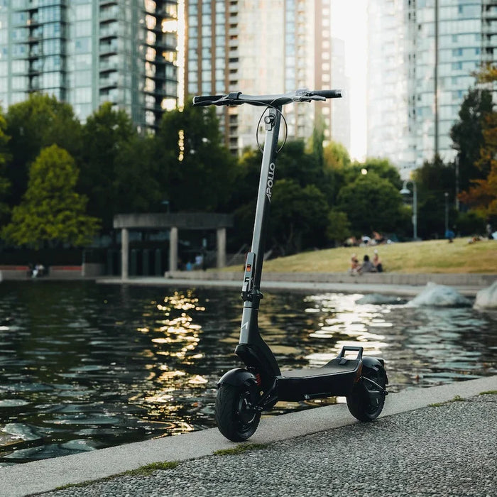 Electric scooter by a body of water with city skyline in the background