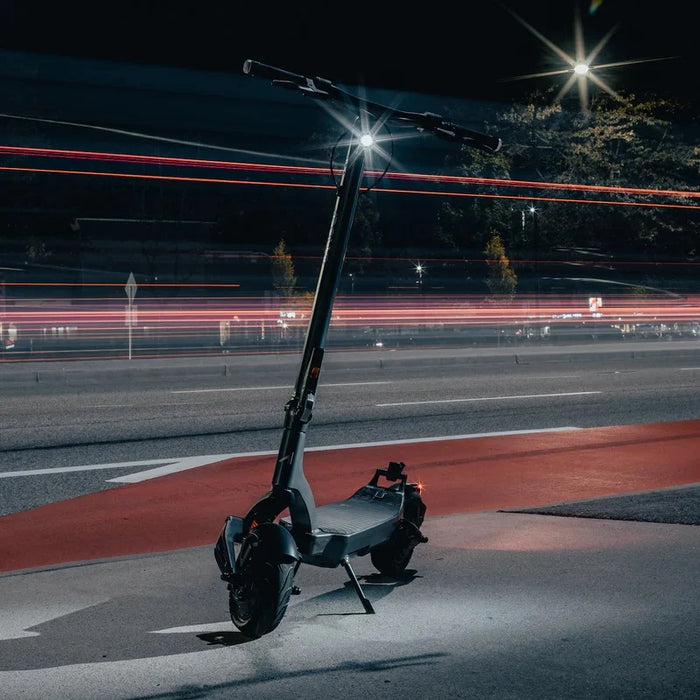 Electric scooter on a road at night with light trails