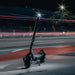 Electric scooter on a road at night with light trails