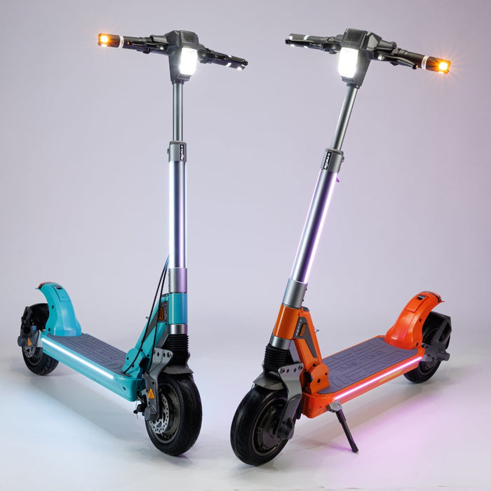 Two electric scooters, one blue and one orange, on a light gray background.