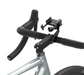 A black bicycle handlebar mount holding a smartphone holder, attached to the stem of a silver road bike with black handlebar tape, on a white background.